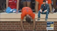 Sad Virginia Fan — A Virginia Cavaliers fan in orange is slumped face-down over brick stadium wall while another dejected fan sits nearby with Notre Dame 32