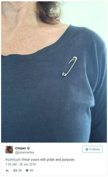 #SafetyPin — Woman in blue top wearing a safety pin on her shoulder, from a tweet by Citizen G