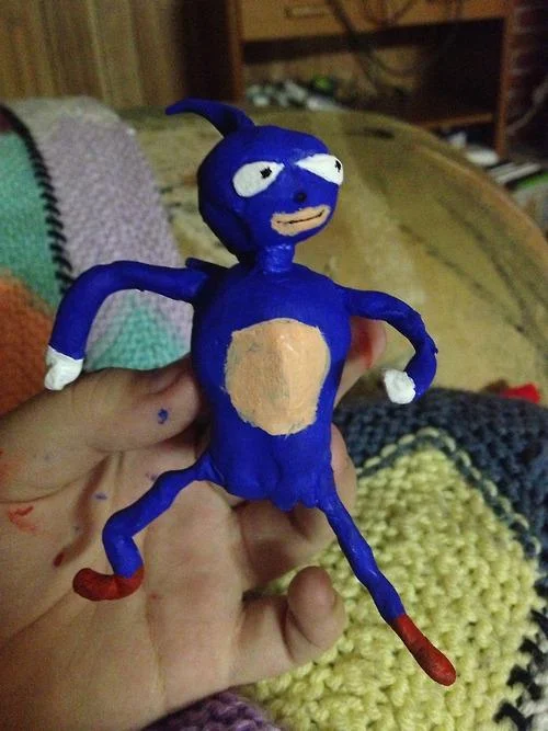 Handmade clay figurine of the Sanic Hegehog meme character held in a hand
