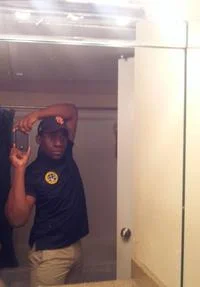A classic bathroom mirror selfie showing a person holding a phone and raising their arm in a doorway, exemplifying the Selfie Olympics format.
