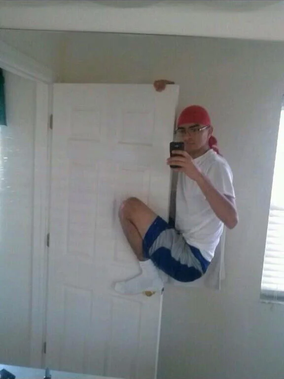 An iconic Selfie Olympics example showing a person in mid-air jumping while taking a bathroom mirror self-portrait.