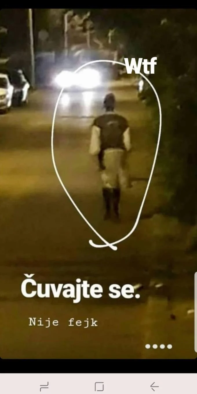 Serbian Dancing Lady — Nighttime photo of a figure in folk costume walking down a road toward headlights, circled with the caption Čuvajte se.
