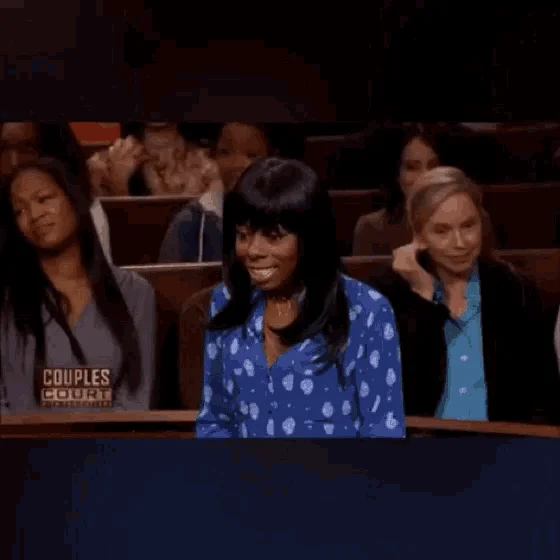 Shocked Judge Dana Cutler — Animated GIF of a woman in a blue blouse reacting with a shocked grin in the Couples Court audience.