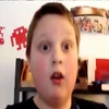 Sir Fedora — A young boy with a surprised open-mouthed expression captured in a low-resolution webcam screenshot in a bedroom setting, typical of early YouTube