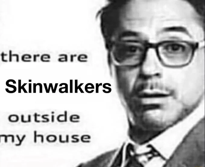 Black-and-white man in glasses with text reading 'there are Skinwalkers outside my house'