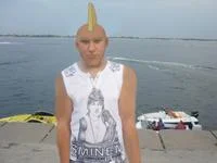 Sminem — A young person with blonde spiky hair wearing an Eminem t-shirt at a beach setting.
