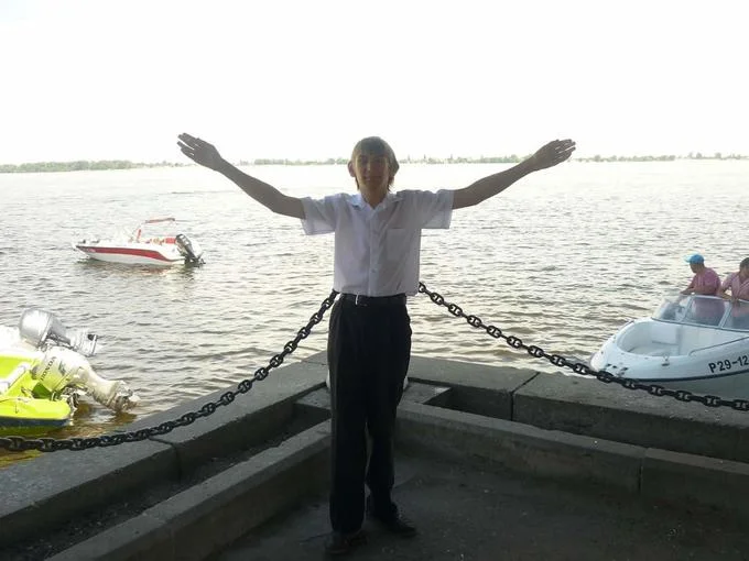 The Sminem character posing with arms spread wide in a triumphant stance on a dock near boats.