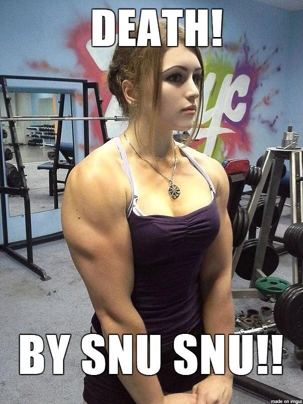 Death By Snu Snu — Tall blonde woman towering over a shorter man indoors