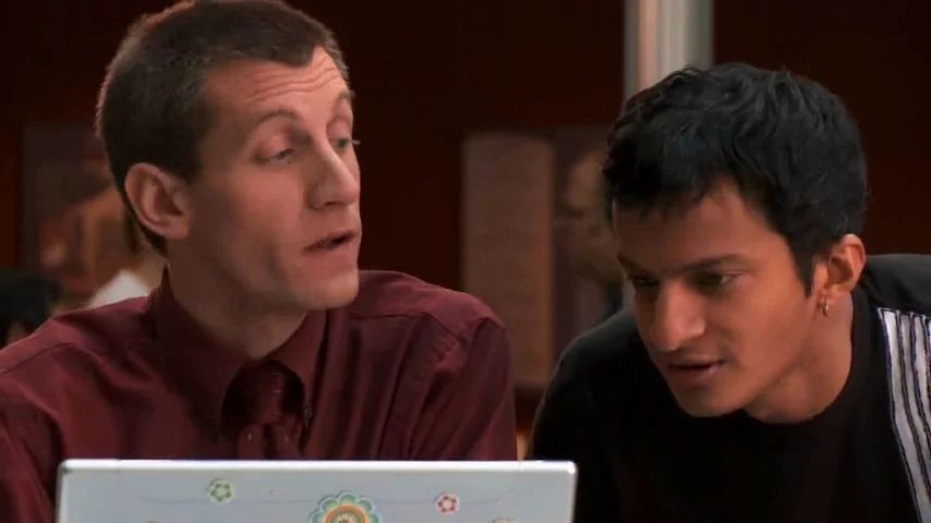 Two men looking at a flower-stickered laptop in the Microsoft Songsmith commercial, with the older man singing excitedly