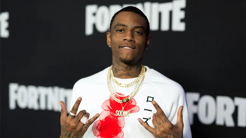 Soulja Boy throws rock hand signs at a Fortnite event red carpet