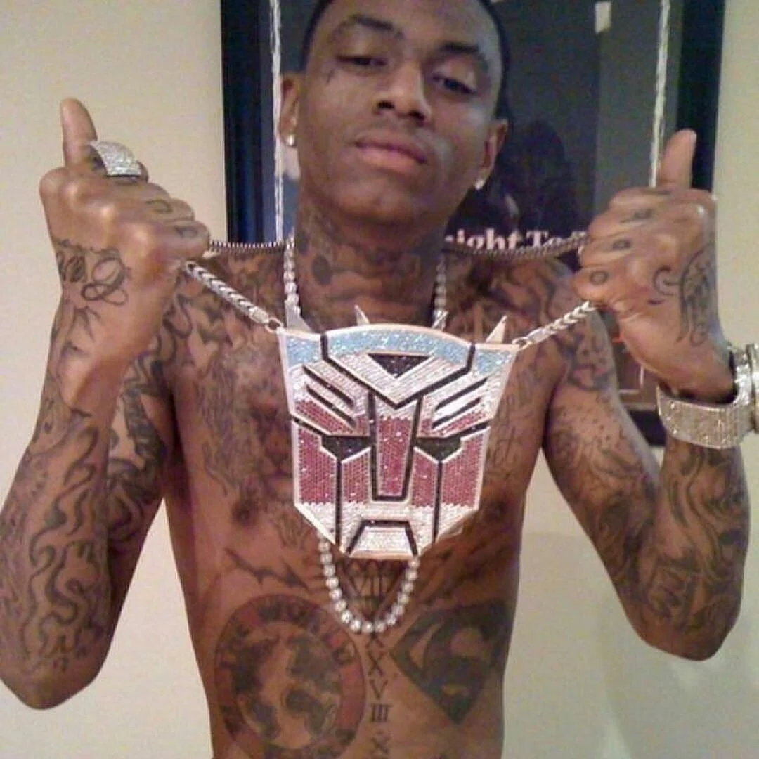 Shirtless Soulja Boy showing off oversized diamond Transformers Autobot chain