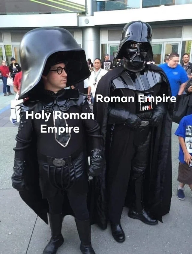 Spaceballs — Darth Vader and Dark Helmet cosplayers side-by-side labeled 'Roman Empire' and 'Holy Roman Empire.'
