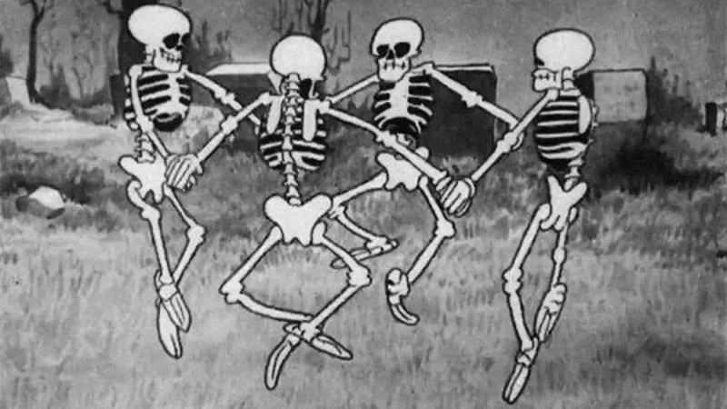 Spooky Scary Skeletons — Four animated skeletons dance in synchronized choreography across a black and white cartoon landscape.