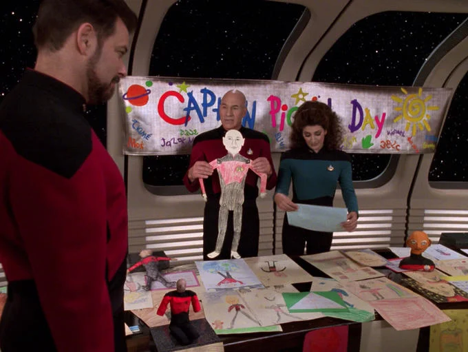 Star Trek — Captain Picard Day celebration scene with Riker, Picard, and Troi