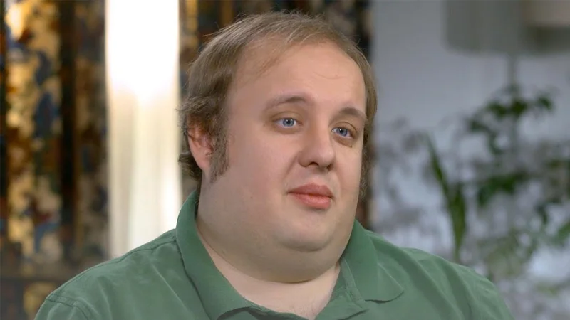 Steven Pruitt in a green polo shirt during a CBS News interview.