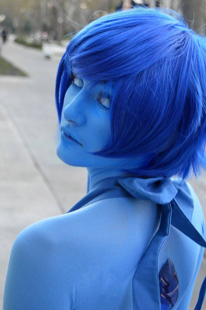Cosplayer with blue skin and blue hair dressed as Lapis Lazuli from Steven Universe.
