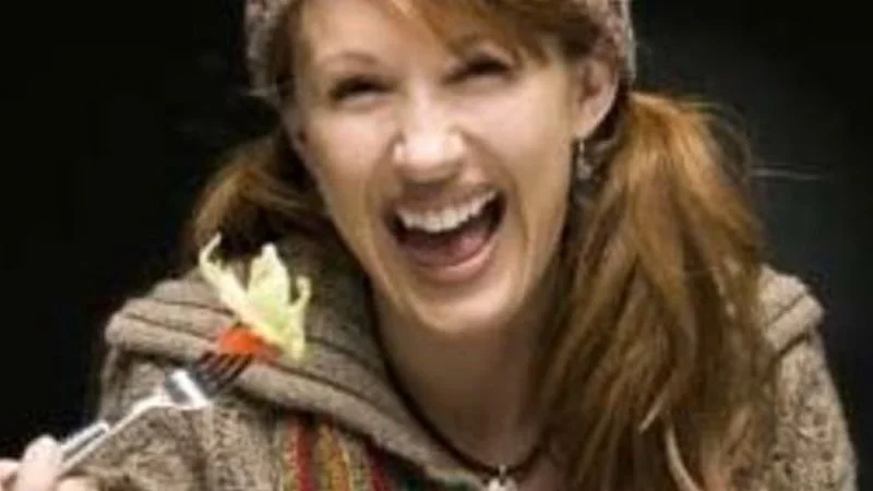 Stock Photo Cliches — Close-up of red-haired woman with exaggerated enthusiasm laughing while holding fork with salad.