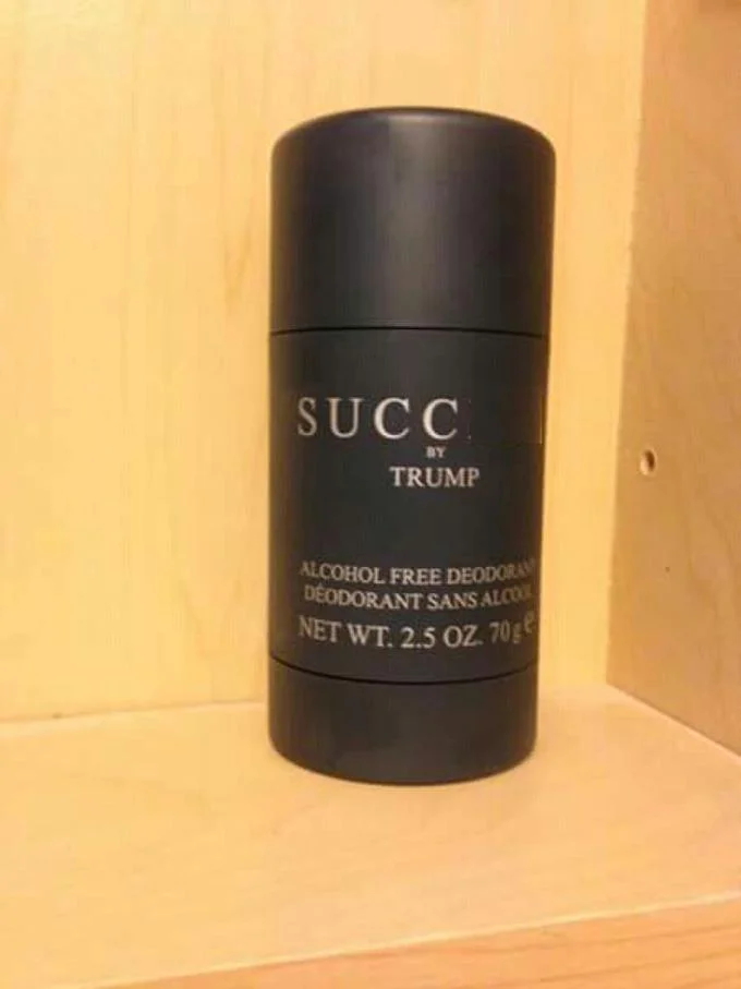 Black deodorant stick labeled SUCC by Trump on a wooden shelf