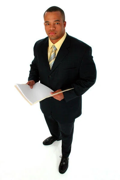 Successful Black Man — Full-body stock photo of a Black man in a suit holding an open folder.