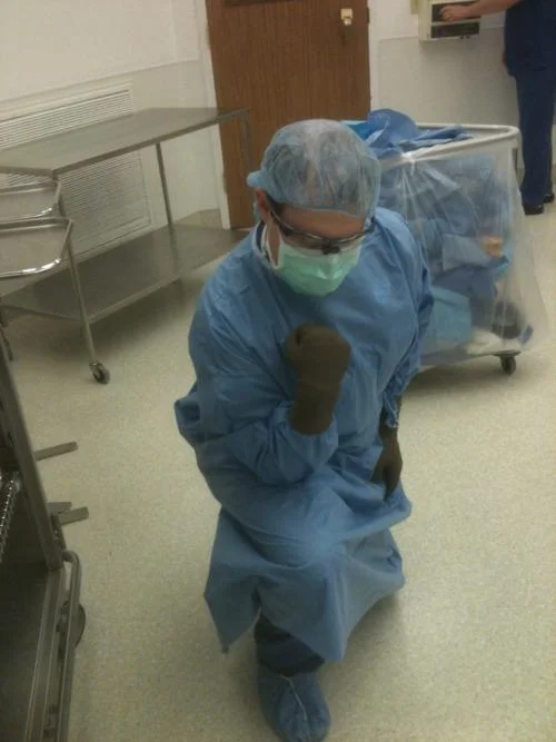 Healthcare worker in full PPE performing Tebowing pose.