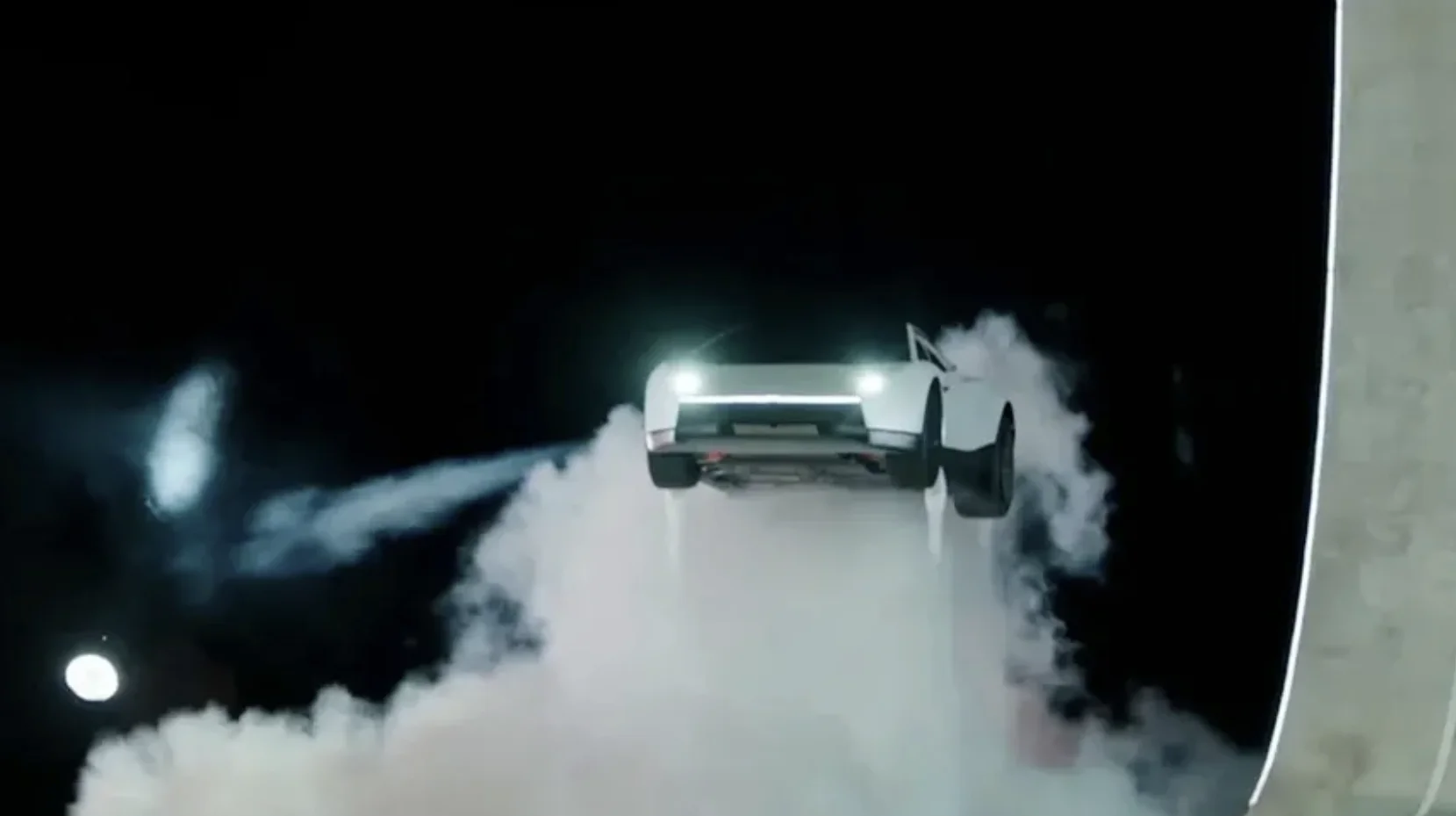 Tesla Roadster Flip — White Tesla Roadster airborne with headlights on, surrounded by clouds of white smoke against a black background.