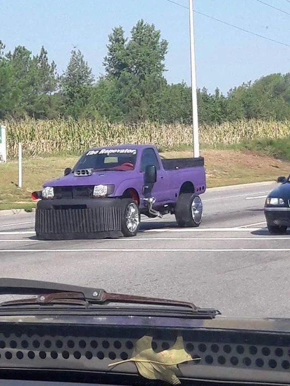 Candid highway photograph of purple Thanos car taken from another vehicle.