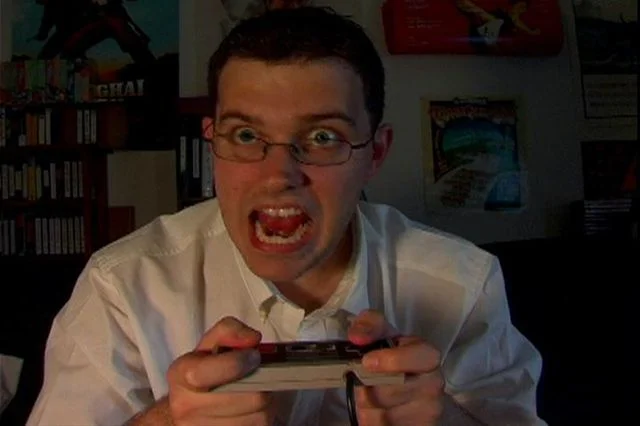James Rolfe as the Angry Video Game Nerd yelling while holding an NES controller