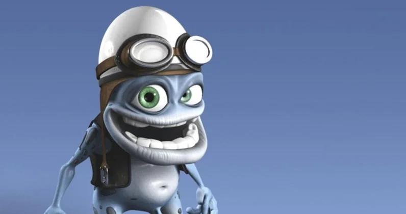 The Annoying Thing — 3D render of Crazy Frog character with aviator helmet and goggles smiling against blue sky