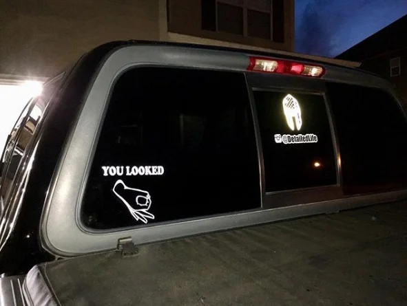 The Circle Game — Pickup truck with YOU LOOKED Circle Game decal on rear window