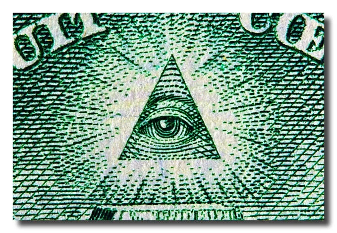 The Illuminati — Close-up of the all-seeing eye within a triangle in green and white, mimicking the design from US currency.