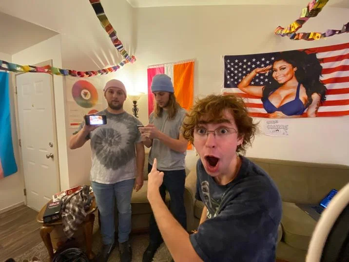 The Ipod Brothers The Fuck You Brothers Sniff And Whimper — Group of five friends pointing at two men holding phones displaying the sniff and whimper meme