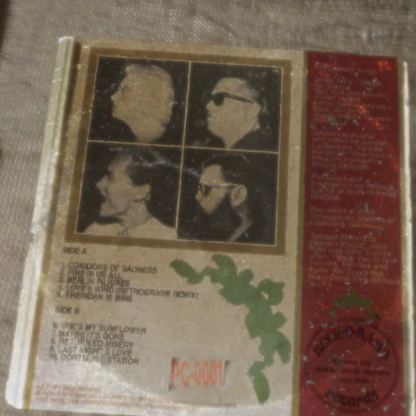 The Most Mysterious Song On The Internet — A photograph of the back cover of a record showing band member portraits and a typed tracklist with catalog number.