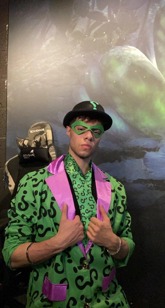 The Rizzler — Portrait photograph of a person wearing bright neon green and pink patterned clothing with sunglasses and hat.