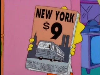 The Simpsons Did It — A screenshot from The Simpsons showing a character holding an orange brochure reading 'NEW YORK $9' with Twin Towers in skyline.