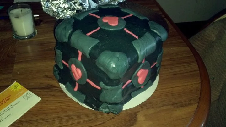 The Weighted Companion Cube — Low-resolution Portal screenshot with Companion Cube and 'PLEASE FORGIVE ME!' caption