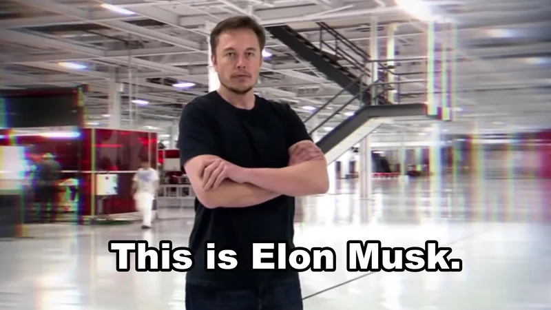 Man standing with arms crossed in industrial warehouse with white text 'This is Elon Musk.' at bottom.