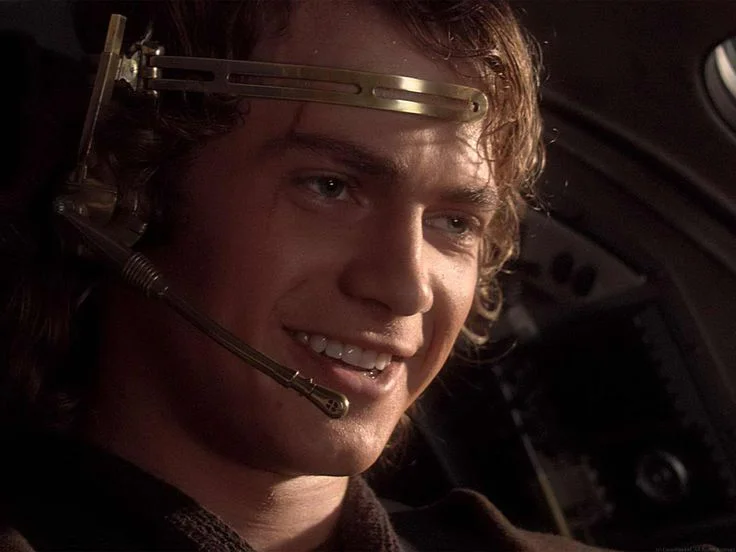 This Is Where the Fun Begins — Anakin Skywalker smiling in starfighter cockpit wearing a gold headset