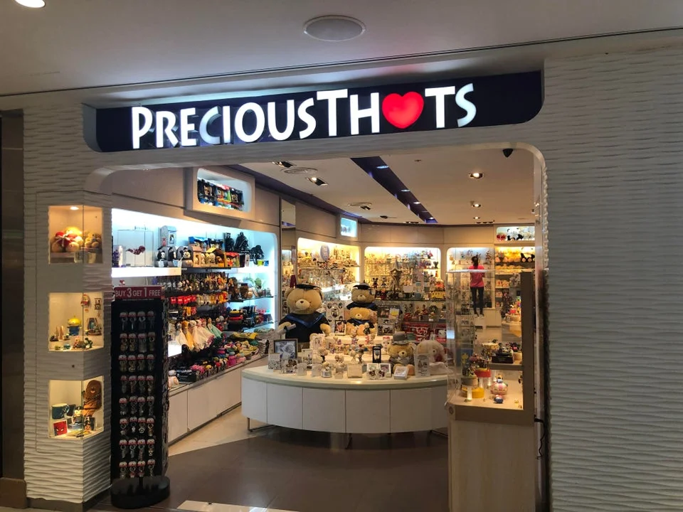 Mall storefront with Precious Thots signage and heart logo