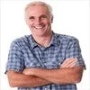 Tim Walz Dad Energy — Professional portrait headshot of man in light blue button-up shirt with arms crossed.