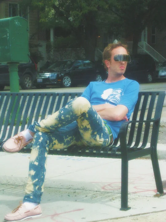 Time Traveling Hipster — Modern hipster man on a park bench wearing futuristic sunglasses, acid-wash jeans and pink boat shoes