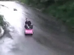 Tokyo Drift In A Barbie Car — Aerial view of man drifting down driveway on battery-powered pink Barbie ride-on toy.