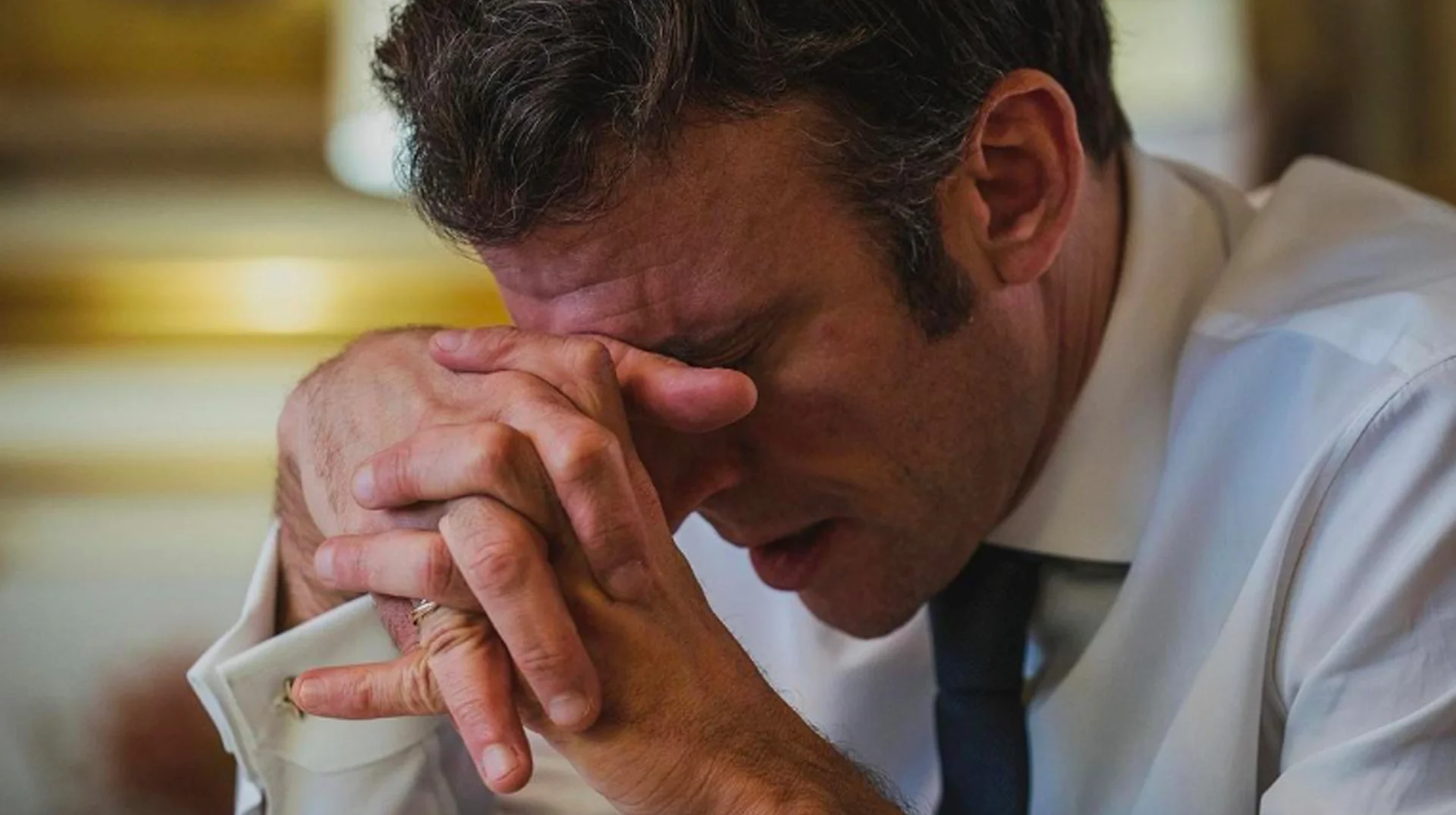 Troubled Macron — Emmanuel Macron rests his forehead on his clasped hands looking distressed