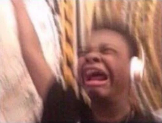 Turn Up the Volume — Young boy with white headphones screaming with excitement and raising his arm
