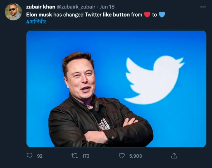 Twitter Changed The Color Of The Like Button — Tweet by Zubair Khan claiming Elon Musk changed the like button from red to blue heart, with photo of Musk