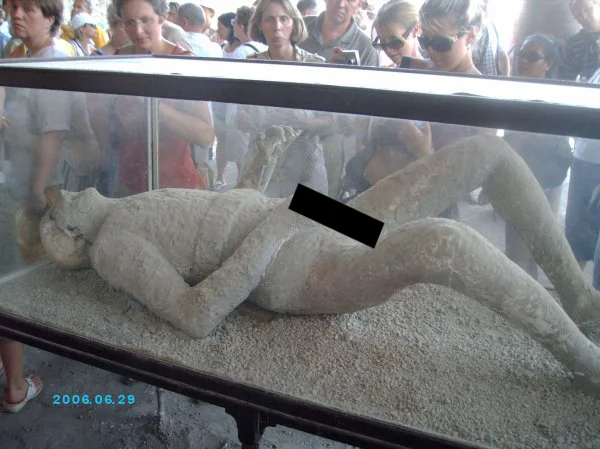 Unnecessary Censorship — Pompeii plaster body cast behind glass with a black censor bar over the pelvis