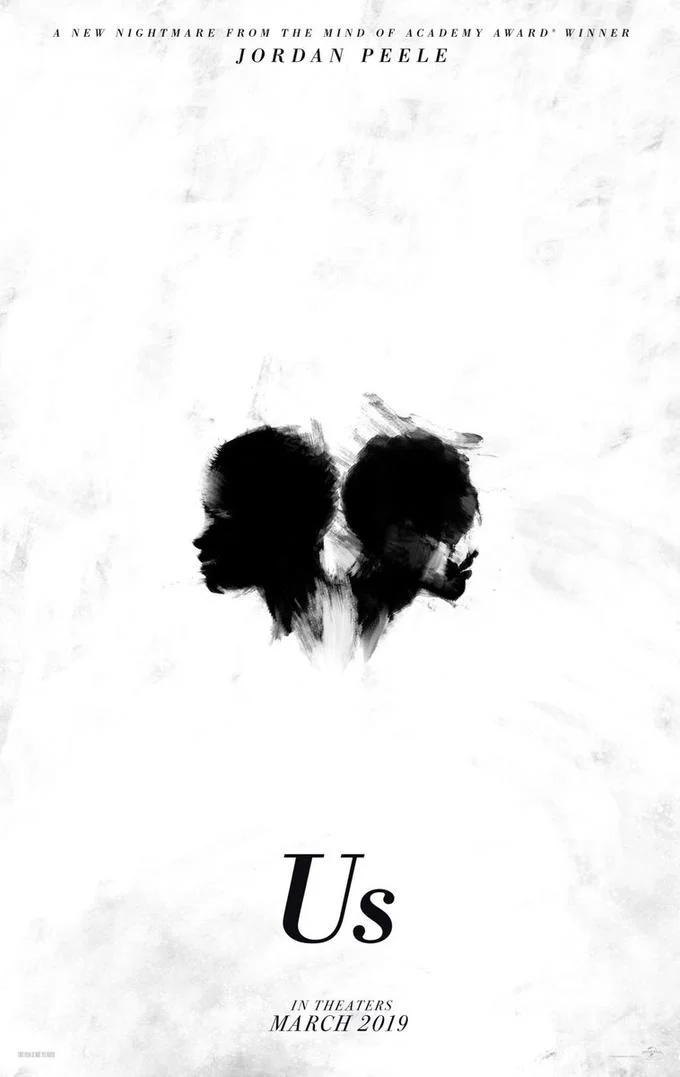Us (2019 Film) — Minimalist Us movie teaser poster with two inkblot silhouettes facing each other, Jordan Peele credit at top and March 2019 release at bottom.