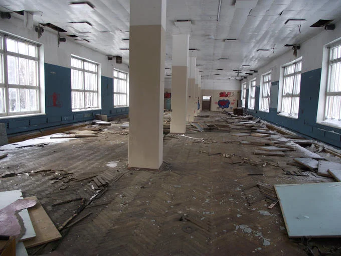 UVB-76 Mystery — Abandoned interior room with debris on parquet floor, peeling ceiling, and blue walls at the UVB-76 facility