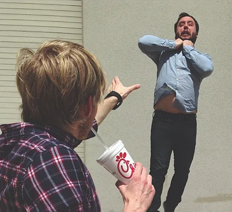 Vadering — Man extending hand toward friend floating with hands at throat in Force choke pose