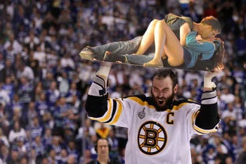 Vancouver Riot Kiss — Bruins captain hoisting couple above head in victory pose.