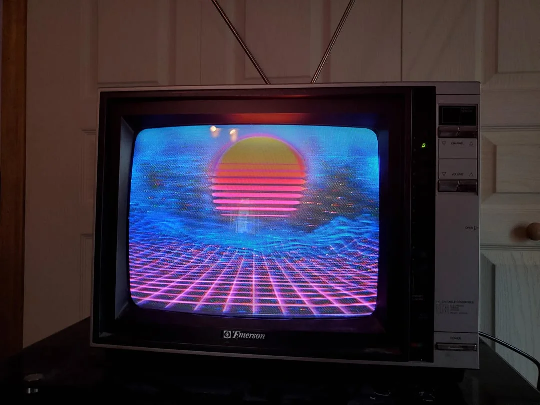 Vintage Emerson CRT TV displaying vaporwave sunset and neon grid landscape